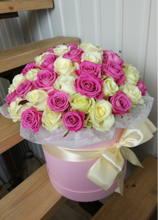 Рожеві та біли троянди у капелюшної коробці